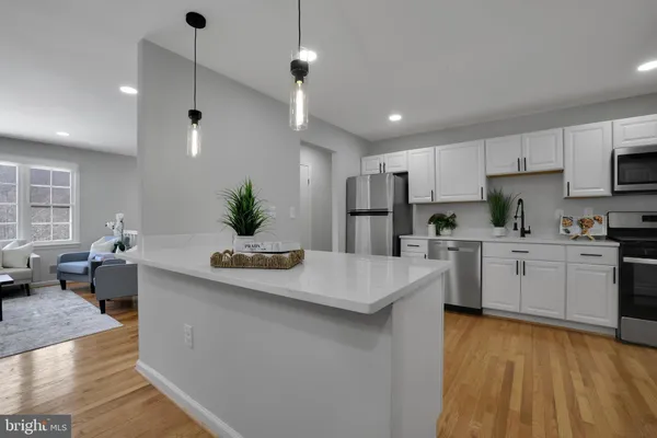 a kitchen with counter top space a sink cabinets and stainless steel appliances