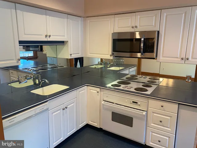 a kitchen with granite countertop a sink stove and cabinets
