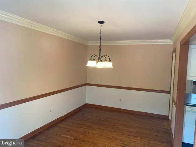 a view of a room with wooden floor and white walls