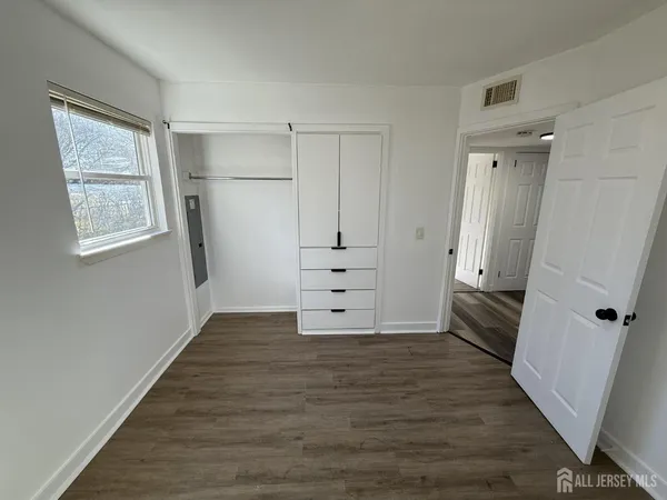 an empty room with wooden floor and window