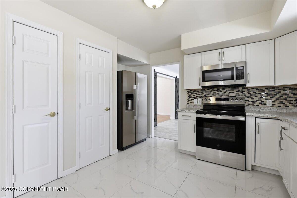 12 Devonshire Lane Mount Pocono, PA 18344 - Photo 13 of 39 a kitchen with stainless steel appliances granite countertop a stove and a refrigerator