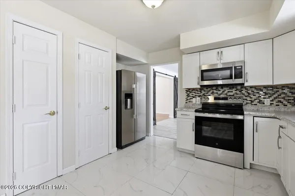 a kitchen with stainless steel appliances granite countertop a stove and a refrigerator
