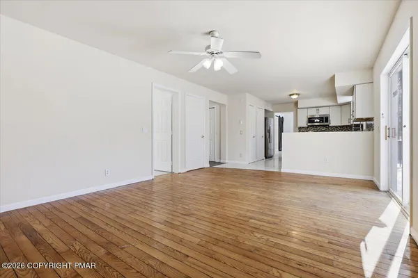 a view of a kitchen with wooden floor and a ceiling fan