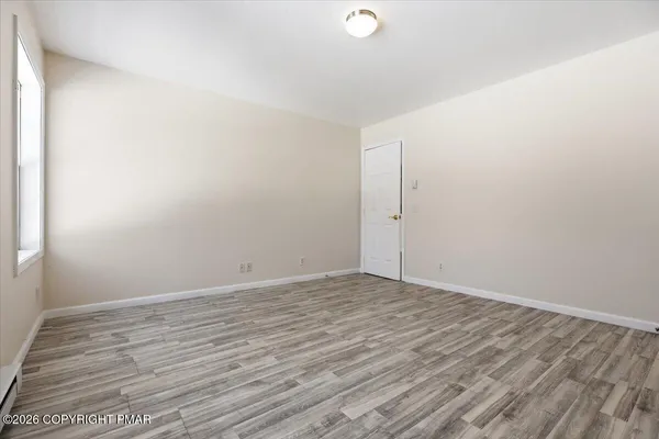 a view of an empty room with wooden floor