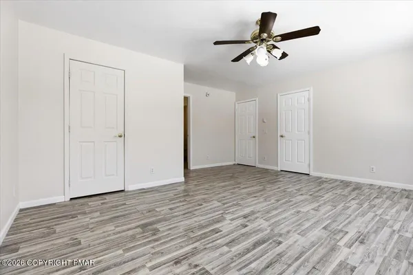 a view of empty room with wooden floor
