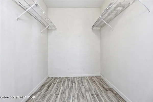a view of walk in closet with empty racks