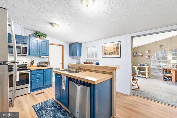 a kitchen with stainless steel appliances granite countertop a sink stove microwave and refrigerator