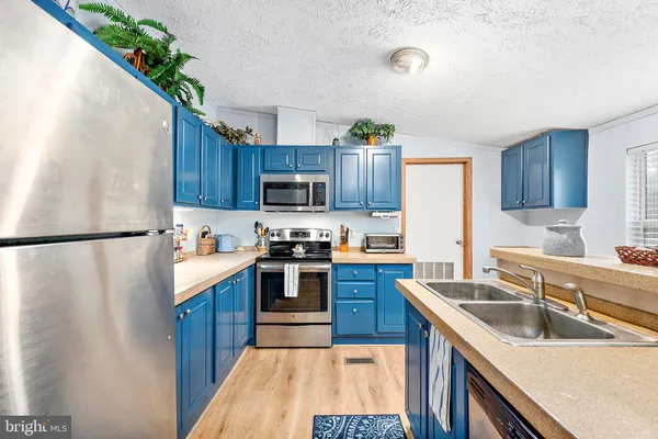 a kitchen with granite countertop wood cabinets and stainless steel appliances