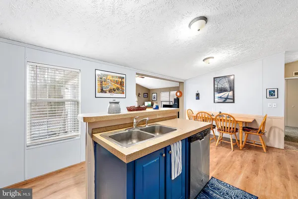 a kitchen with kitchen island granite countertop wooden floors and wooden cabinets