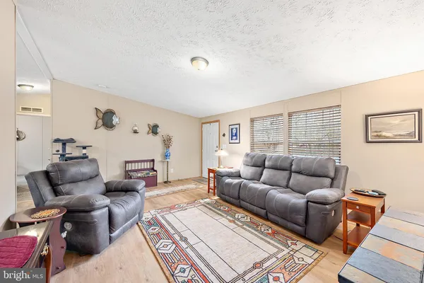 a living room with furniture a rug and a kitchen view