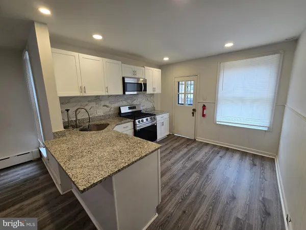 a kitchen with stainless steel appliances granite countertop wooden cabinets a sink dishwasher a stove and a refrigerator