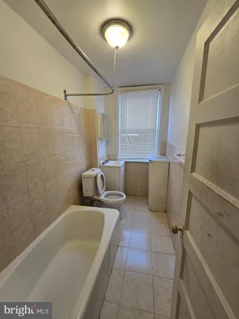 a bathroom with a tub sink and shower