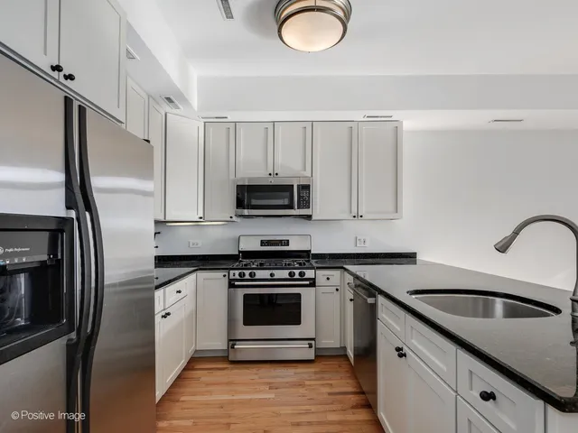 a kitchen with stainless steel appliances granite countertop a stove top oven a sink and dishwasher