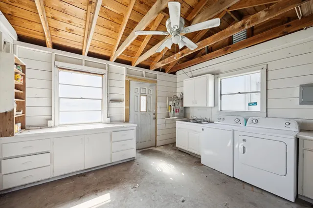 a large white kitchen with cabinets and a window
