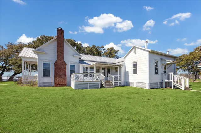 a front view of house with yard barbeque and outdoor seating