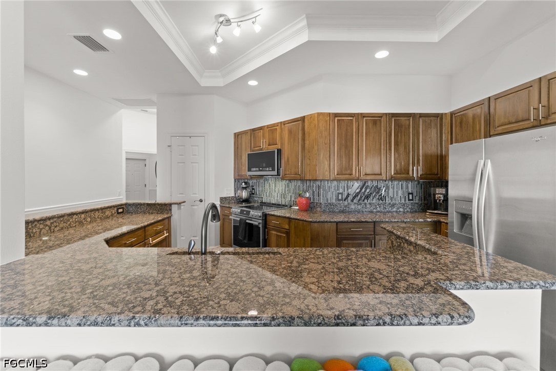 2743 First Street, Unit 2703 Fort Myers, FL 33916 - Photo 8 of 50 a kitchen with stainless steel appliances granite countertop a sink a stove a refrigerator cabinets and chairs