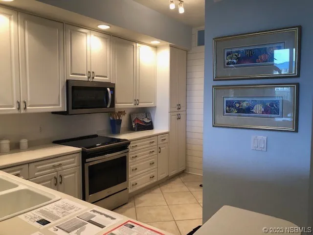 a kitchen with stainless steel appliances wooden cabinets and stove top oven