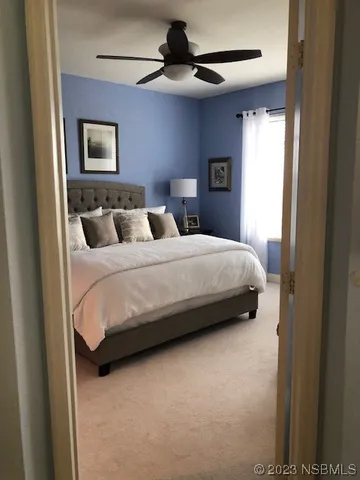 a bedroom with a bed a chandelier and a window