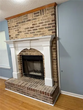 a view of empty room with wooden floor and fireplace