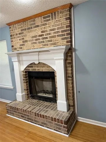 a view of empty room with wooden floor and fireplace