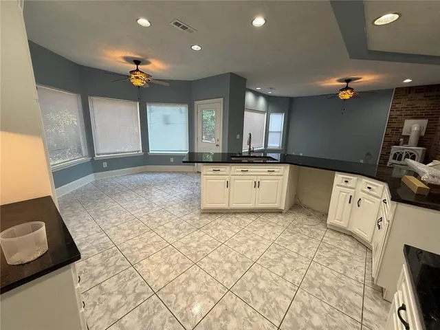 a large kitchen with kitchen island a sink stainless steel appliances and cabinets