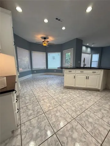 a large kitchen with stainless steel appliances a stove a sink a counter top space and cabinets