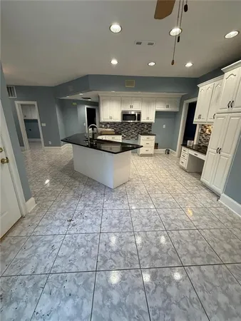 a kitchen with stainless steel appliances a sink a stove a microwave and cabinets