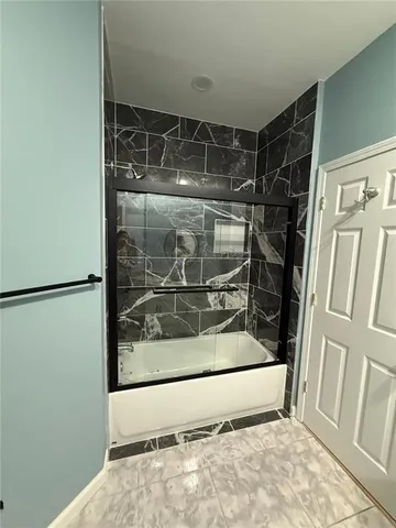 a large white kitchen with stainless steel appliances kitchen island granite countertop a stove a sink a microwave and a refrigerator