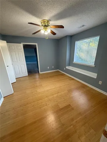 a view of a livingroom with a dinning area a ceiling fan and window