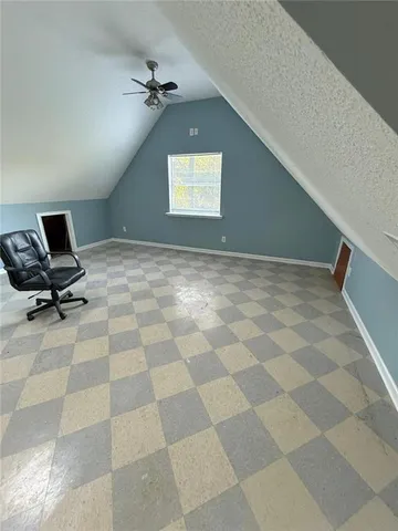 a view of an empty room with a chandelier fan