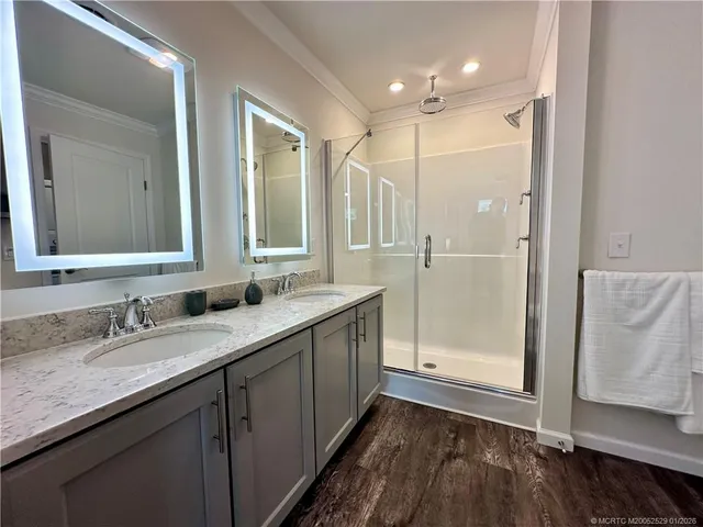 a bathroom with a double vanity sink mirror and shower