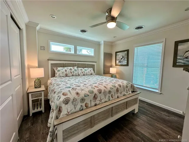a bedroom with a bed next to a window with a chandelier