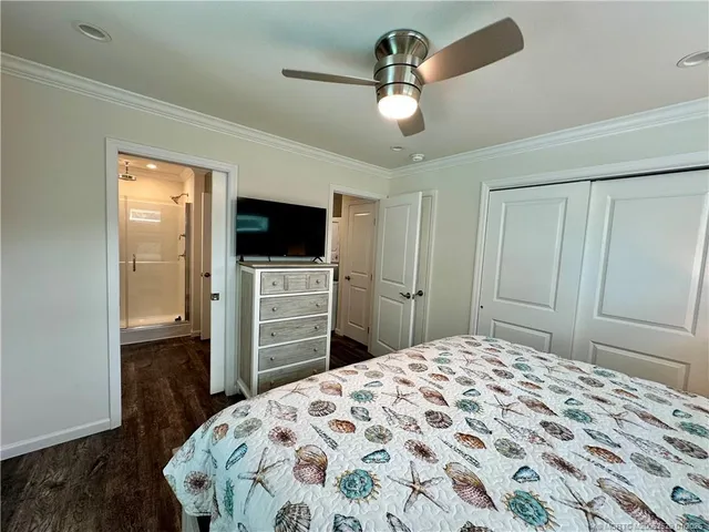 a bedroom with a bed and a flat tv screen on dresser