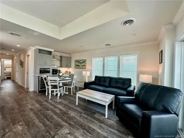 a living room with furniture and a dining table with kitchen view