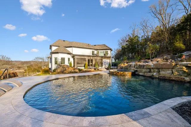 a front view of a house with a yard and a garden