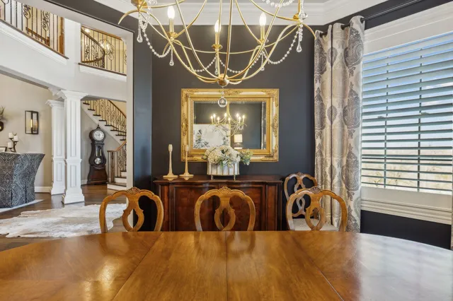 a view of a dining room with furniture large windows and a chandelier
