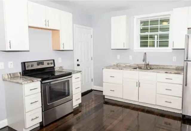 a kitchen with granite countertop white cabinets and white appliances
