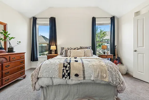 a bed sitting in a bedroom next to a window