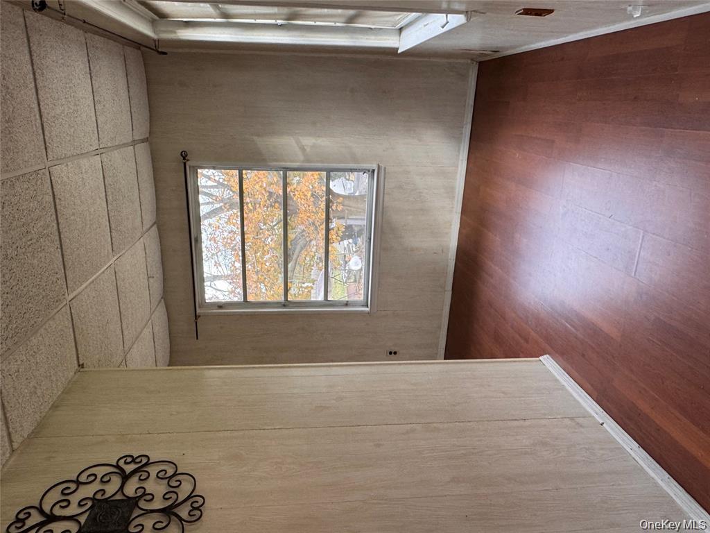 113 Brewery Road New City, NY 10956 - Photo 11 of 39 Empty room with a drop ceiling, dark wood finished floors, and wooden walls