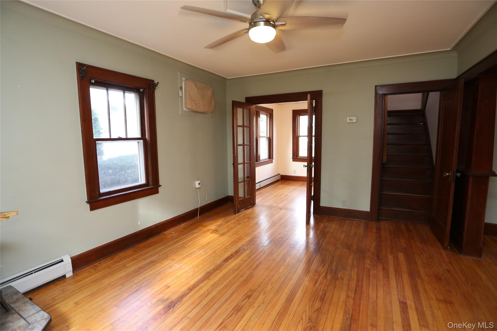 113 Brewery Road New City, NY 10956 - Photo 14 of 39 Empty room featuring stairway, hardwood / wood-style flooring, ceiling fan, and french doors