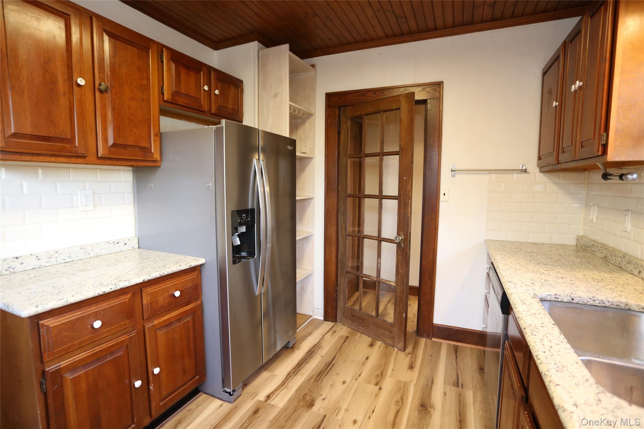 113 Brewery Road New City, NY 10956 - Photo 16 of 39 Kitchen with backsplash, light stone countertops, appliances with stainless steel finishes, open shelves, and brown cabinetry