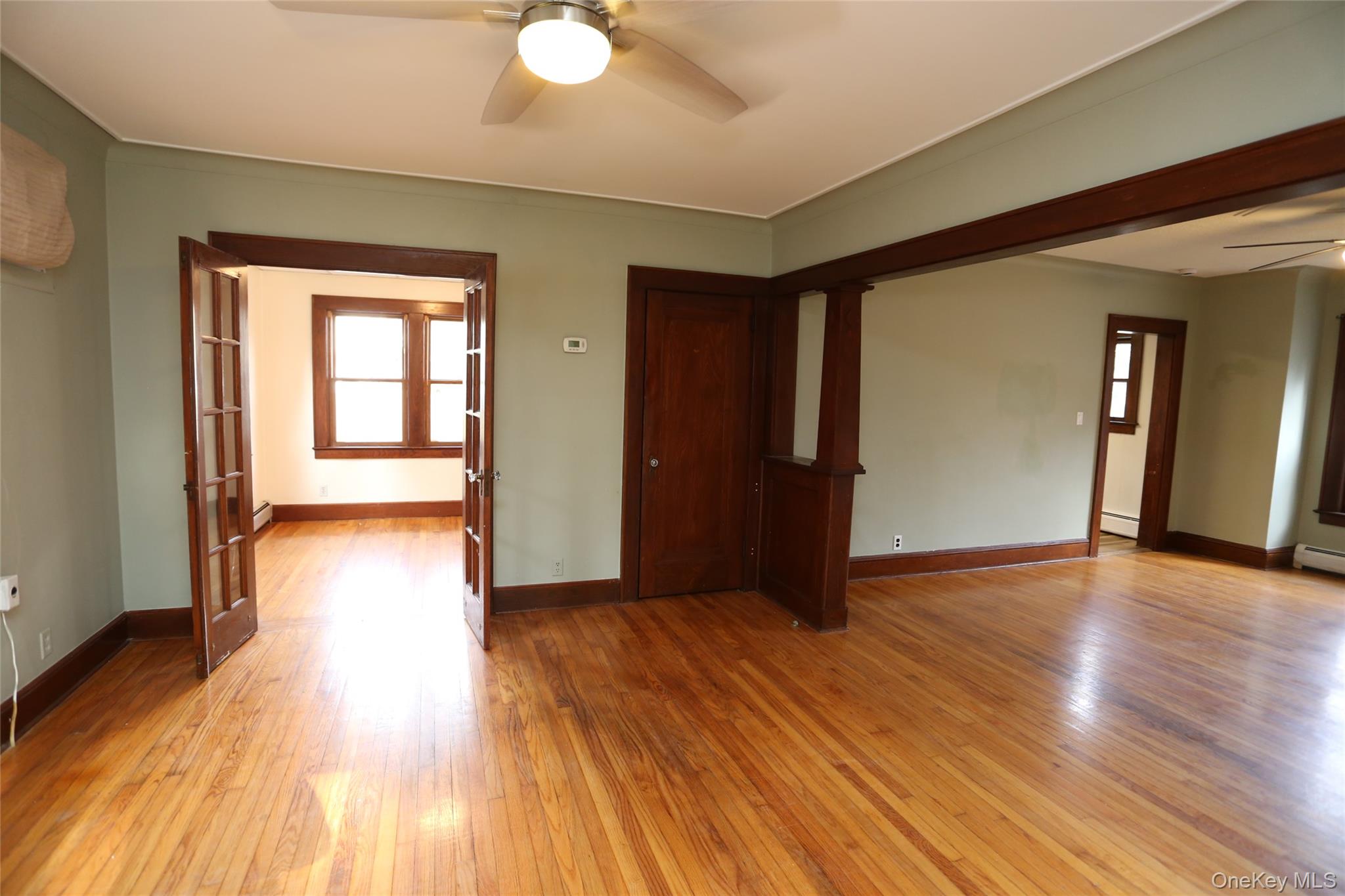 113 Brewery Road New City, NY 10956 - Photo 19 of 39 Empty room with ceiling fan, light wood-type flooring, french doors, and a baseboard heating unit