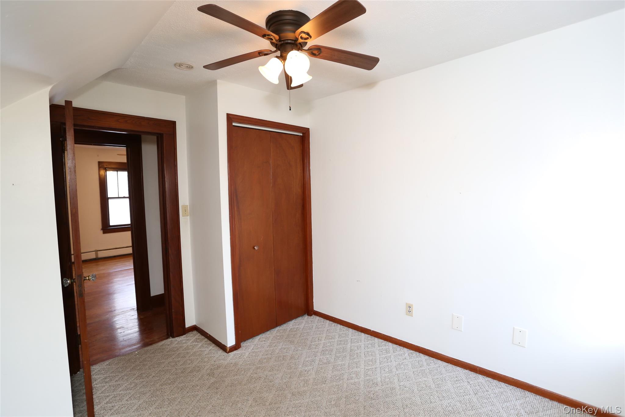 113 Brewery Road New City, NY 10956 - Photo 23 of 39 Unfurnished bedroom with light carpet, a closet, a ceiling fan, and a baseboard heating unit