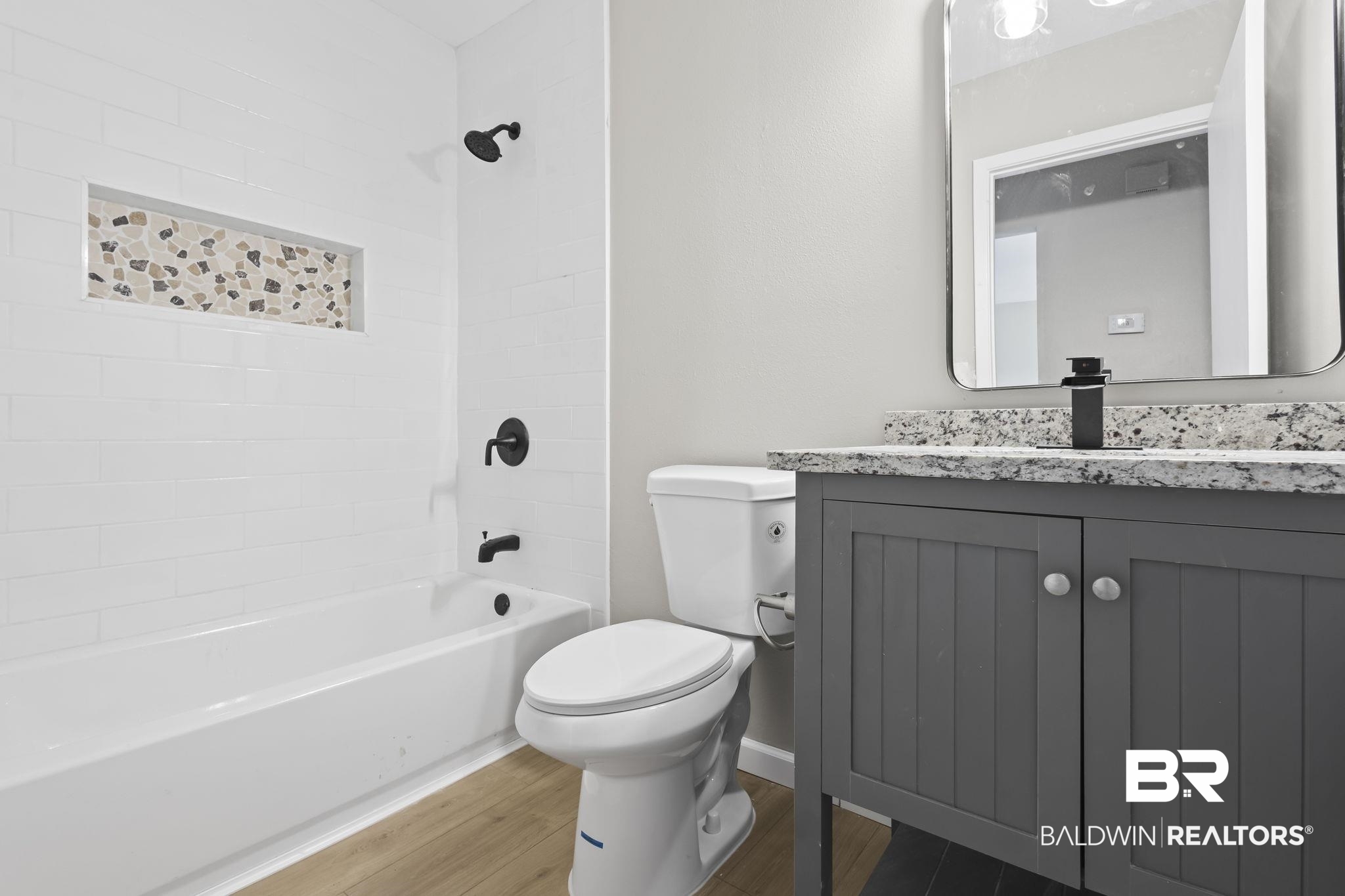 309 West Roosevelt Avenue Foley, AL 36535 - Photo 12 of 60 Full bathroom with vanity, toilet, wood-type flooring, and tiled shower / bath