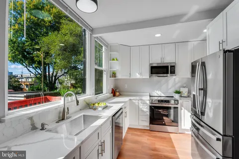 a kitchen with stainless steel appliances a stove a sink and a microwave
