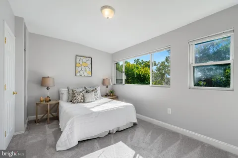 a bedroom with a bed and a lamp on the dresser