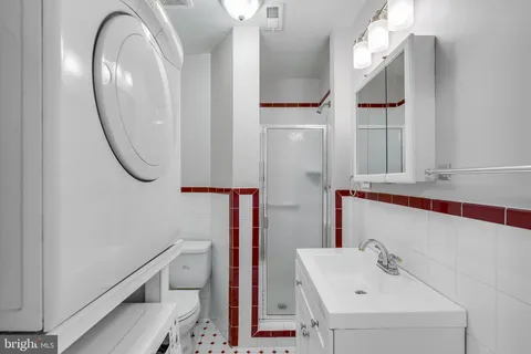 a bathroom with a sink a toilet a mirror and shower