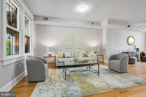 a living room with furniture lamp and window