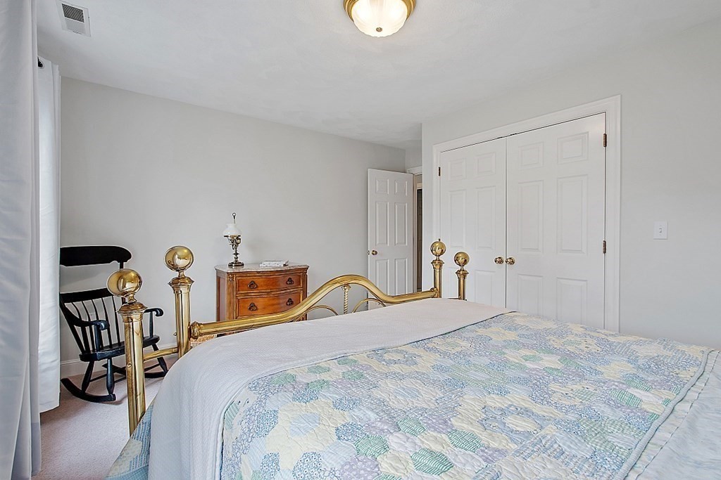 195 Lancaster Road North Andover, MA 01845 - Photo 27 of 42 a bedroom with a bed and a chandelier