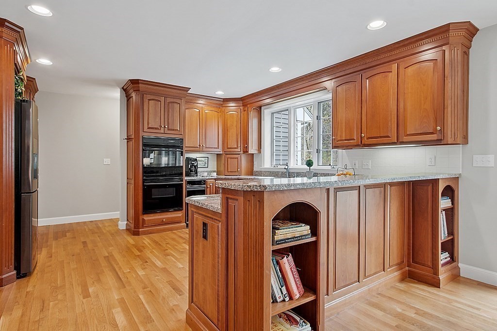 195 Lancaster Road North Andover, MA 01845 - Photo 6 of 42 a kitchen with granite countertop a refrigerator and wooden cabinets